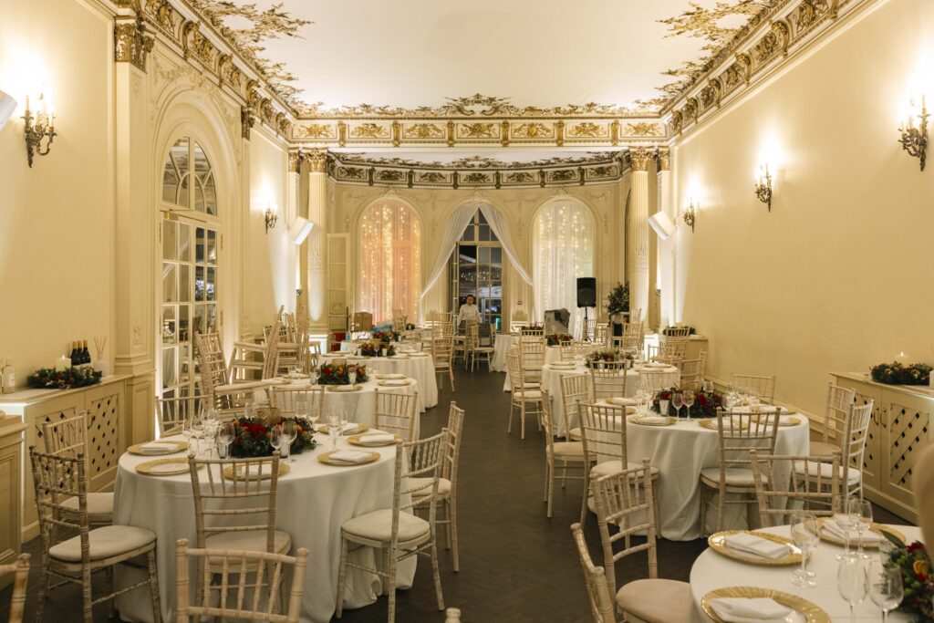 A Christmas party setup for dinner, with round tables with festive centrepieces